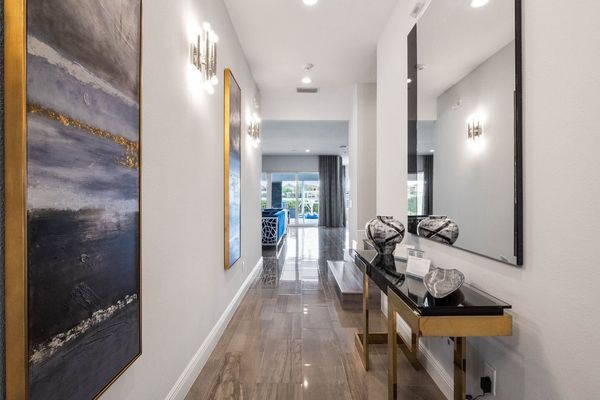 Adorned with exquisite paintings and a grand mirror, it's a corridor of elegance leading to the pool area.