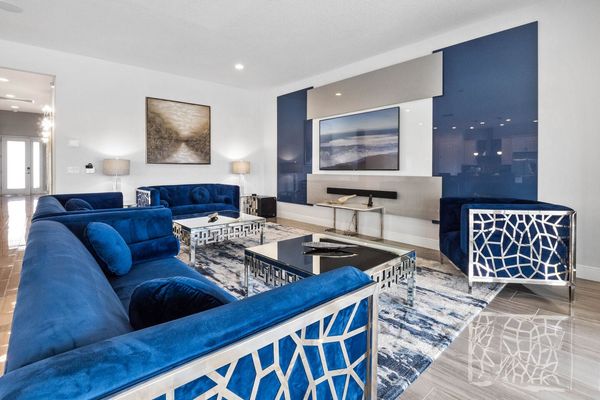 Sink into serenity in our expansive living room, where the tranquil blue tones of the couch harmonize with the plush carpet beneath, inviting you to unwind in absolute comfort.
