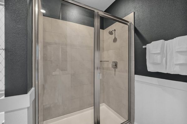 Refresh yourself in the modern shower area, featuring sleek fixtures and ample space for a rejuvenating experience