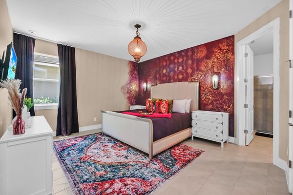 Escape to the vibrant master bedroom, a spacious retreat adorned with colorful decor and comfortable furnishings