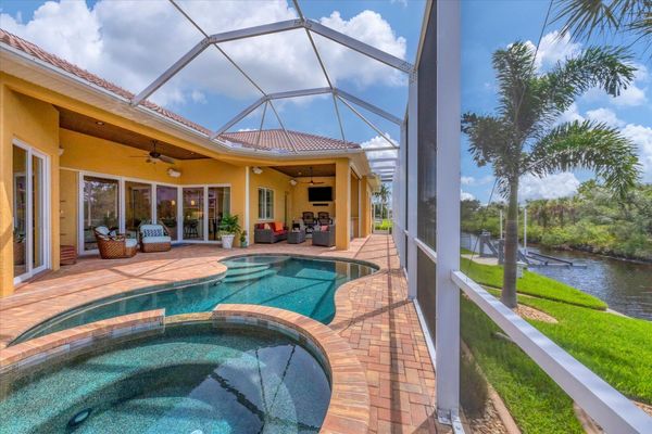 Large outdoor living space overlooking canal and nature preserve. Lanai features ample seating, outdoor kitchen, bar, 65-inch Smart TV, sparkling private pool & spa, and remote controlled privacy screens. Pool size is 17'L x 10'W x 6'D