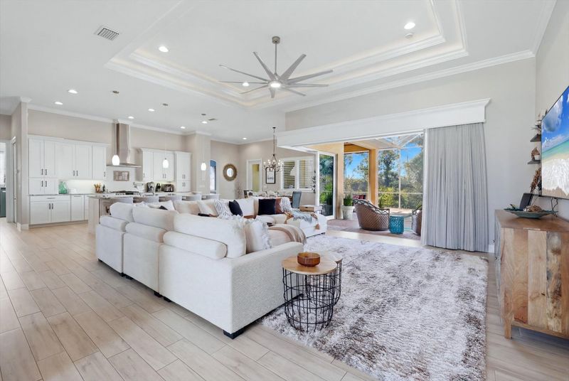 Gorgeous, open living space overlooking private pool, canal, and nature preserve beyond. Living room features lots of comfy seating and 70-inch Smart TV
