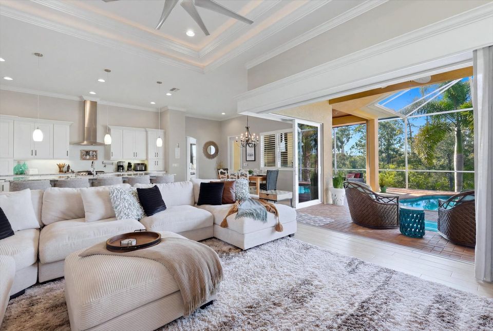 Gorgeous, open living space overlooking private pool, canal, and nature preserve beyond. Living room features lots of comfy seating and 70-inch Smart TV