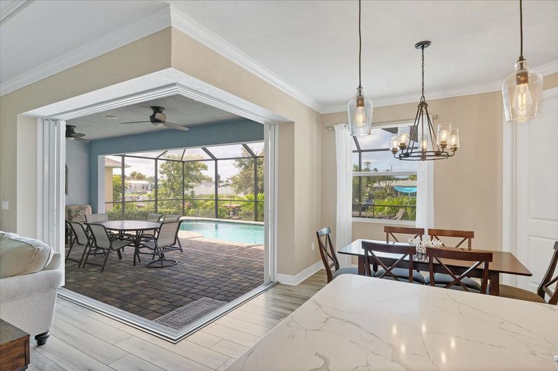 Kitchen and dining area overlooking the sparkling pool and canal