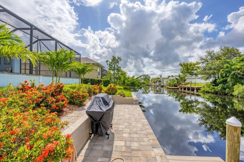 BBQ grill in backyard with path leading to boat dock and canal (Boat lift not available)