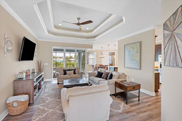 Large living room overlooking pool. Living room features comfy, ample seating and large 65-inch Smart TV