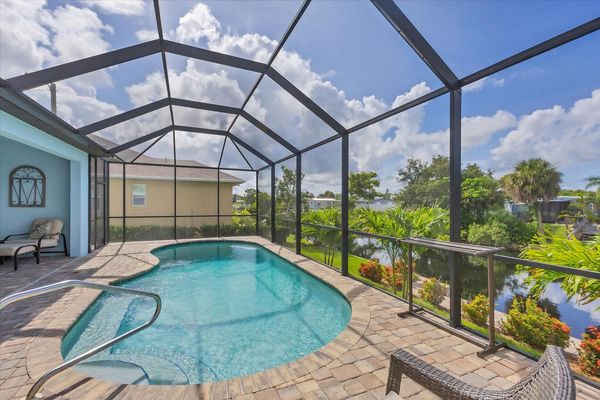 Gorgeous, large lanai with sparkling pool overlooking the canal. Lanai also features a dining table for 6 and 32-inch Smart TV. Pool size: 22' x 8' x 6'D