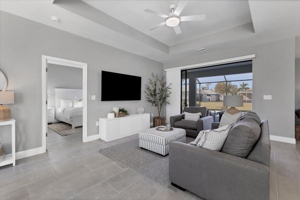 Living room overlooks the pool and features comfy seating and a 55" Smart TV