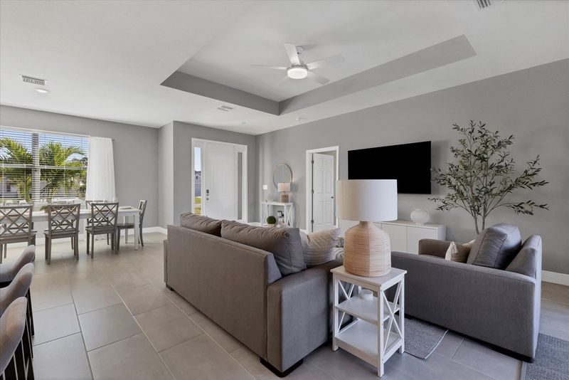 Living room overlooks the pool and features comfy seating and a 55" Smart TV