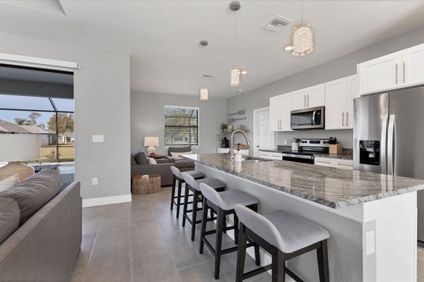 Fully equipped kitchen overlooking living room and dining area. Kitchen island seats 4