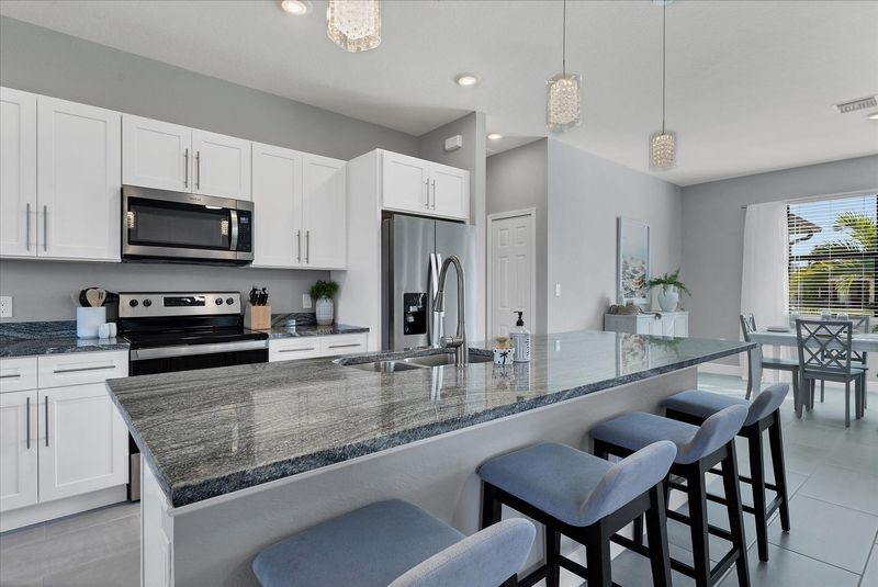 Fully equipped kitchen overlooking living room and dining area