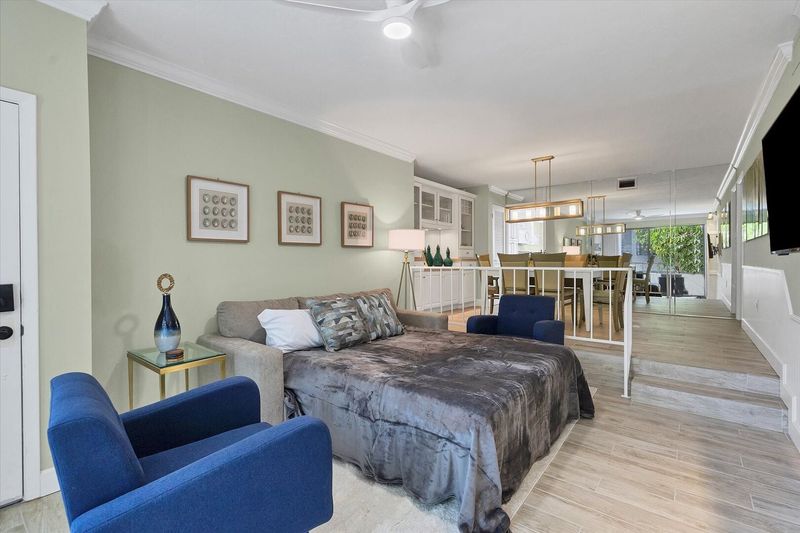 Living room with 55-inch TV, balcony access, and queen sofa bed