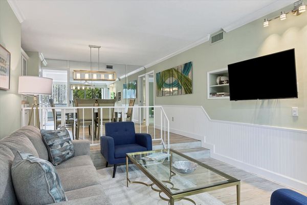Living room with 55-inch TV, balcony access, and queen sofa bed