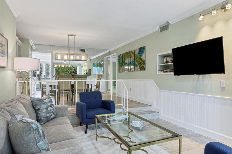 Living room with 55-inch TV, balcony access, and queen sofa bed