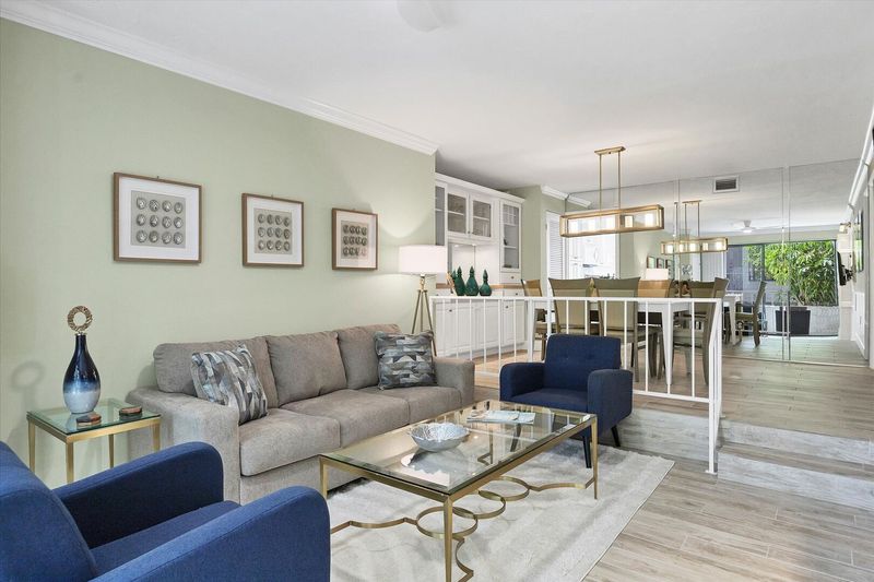 Living room with 55-inch TV, balcony access, and queen sofa bed