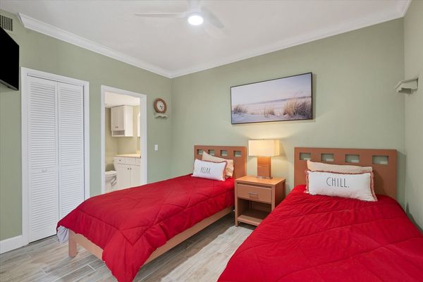 Guest bedroom features 2 twin beds, 32-inch Smart TV and attached bathroom
