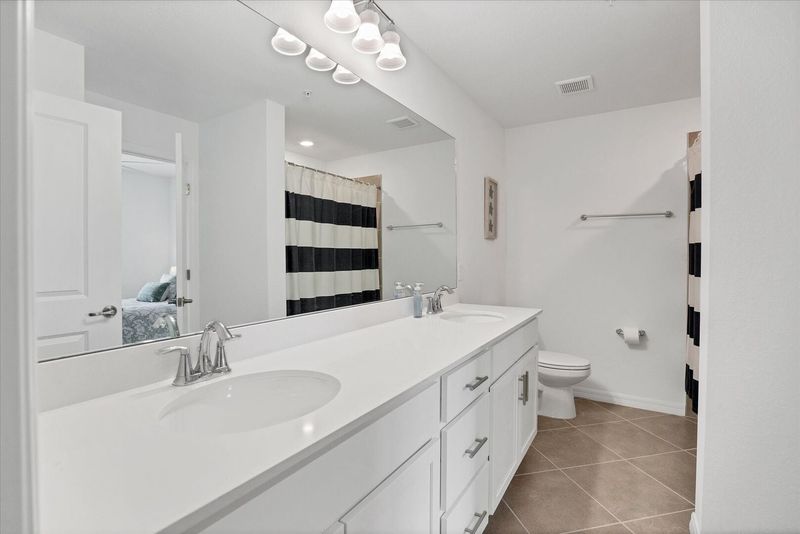 Guest bathroom with double vanities and shower/tub combo