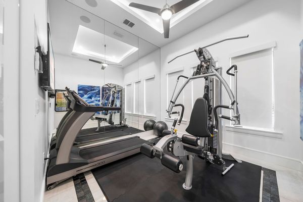Glass Enclosed Workout Room with Mirror and TV