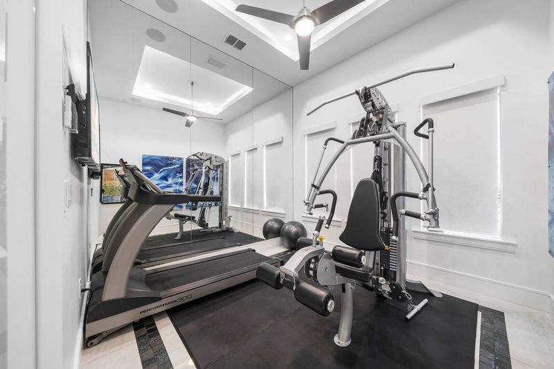 Glass Enclosed Workout Room with Mirror and TV