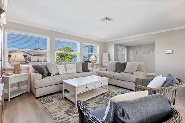 Bright, open living room with lots of comfy seating and 65-inch Smart TV