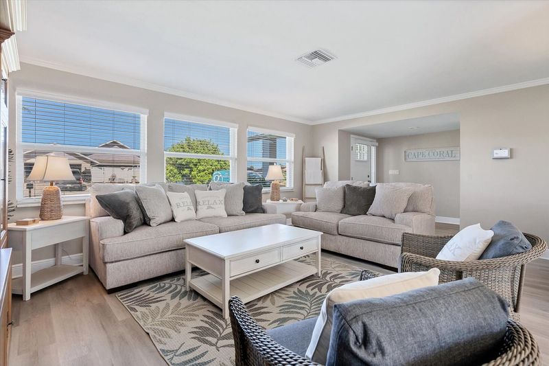 Bright, open living room with lots of comfy seating and 65-inch Smart TV