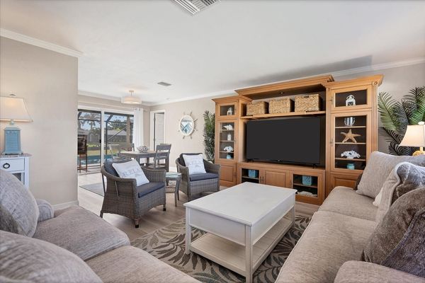 Bright, open living room with lots of comfy seating and 65-inch Smart TV