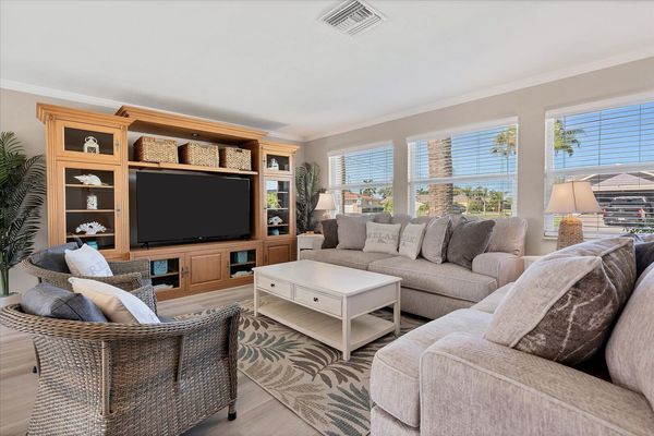 Bright, open living room with lots of comfy seating and 65-inch Smart TV