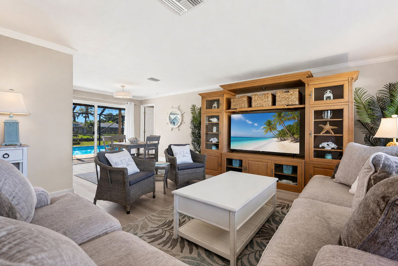 Bright, open living room with lots of comfy seating and 65-inch Smart TV