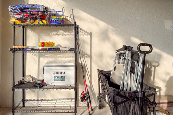 Lots of beach supplies including chairs, cooler, fishing poles, and more