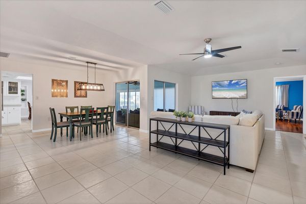 Large, open living area. Living room features a 65-inch Smart TV. Dining rable seats 6
