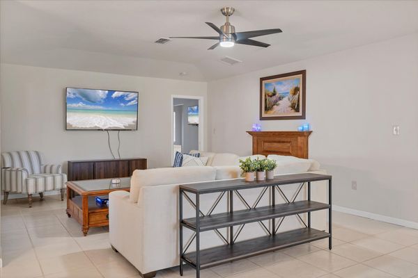 Large, open living area. Living room features comfy seating and a 65-inch Smart TV.