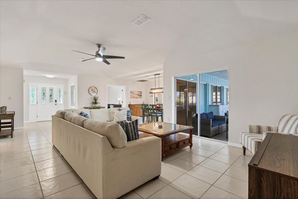 Large, open living area. Living room features comfy seating and a 65-inch Smart TV.