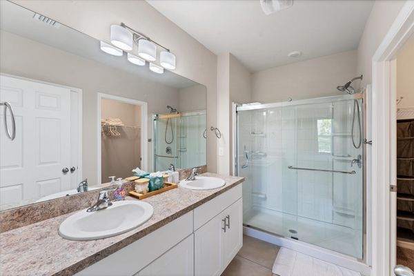 Primary attached bathroom with walk-in shower and double vanities