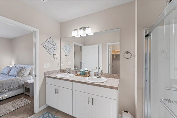 Primary attached bathroom with walk-in shower and double vanities