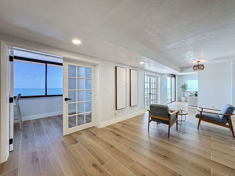 Sitting area and French door opening to the enclosed balcony