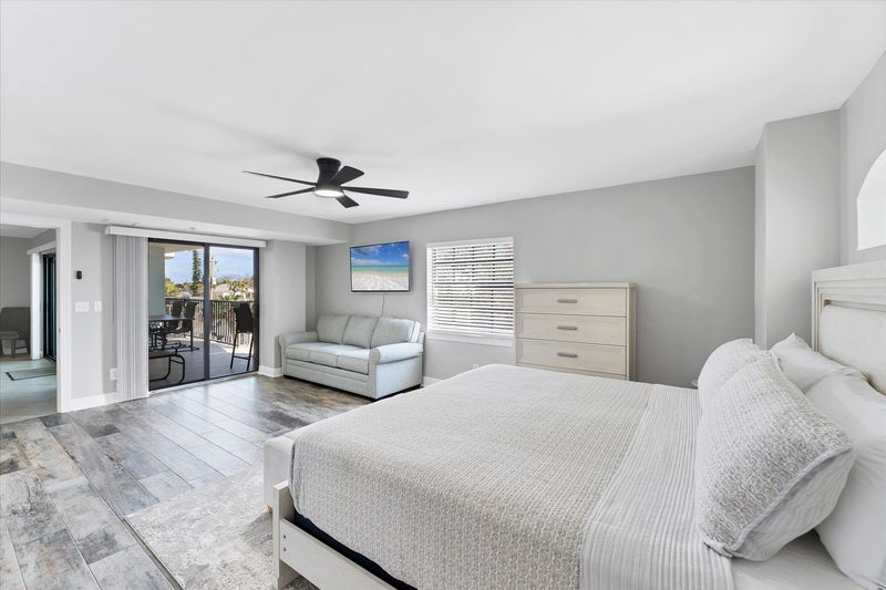 Primary Bedroom With King Bed,  attached bathroom, 50-inch Smart TV, and balcony access