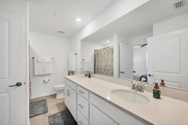 Primary attached bathroom with walk-in shower and double vanities