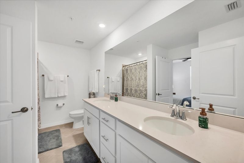 Primary attached bathroom with walk-in shower and double vanities