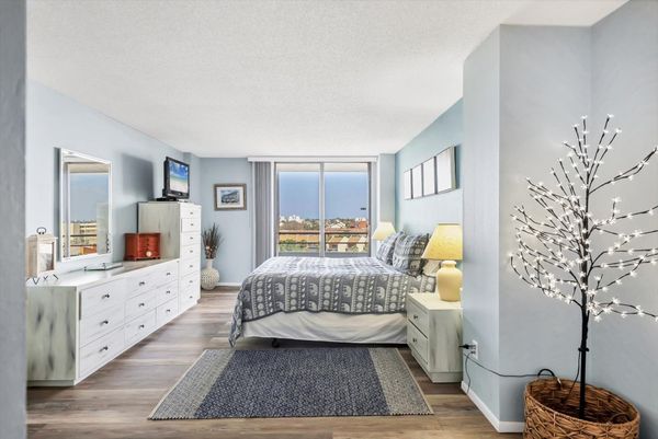 Primary Bedroom with king bed, en suite, balcony access, and a 32" TV
