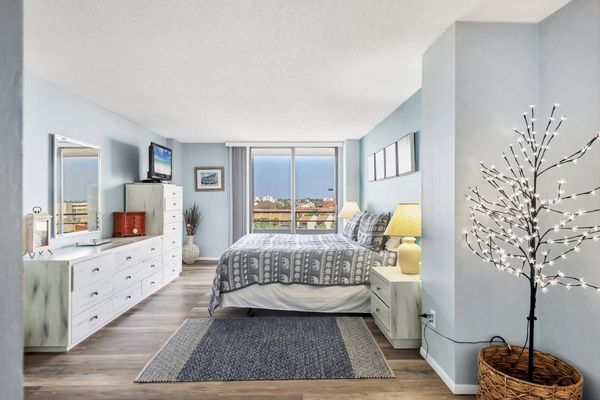 Primary Bedroom with king bed, en suite, balcony access, and a 32" TV