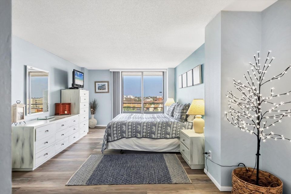 Primary Bedroom with king bed, en suite, balcony access, and a 32" TV
