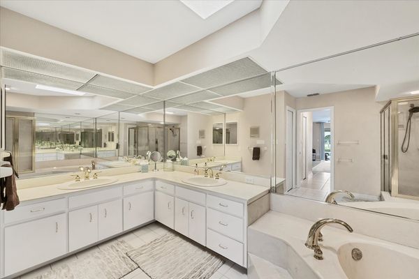 Primary Bathroom with large walk-in shower, double vanities, and bath tub