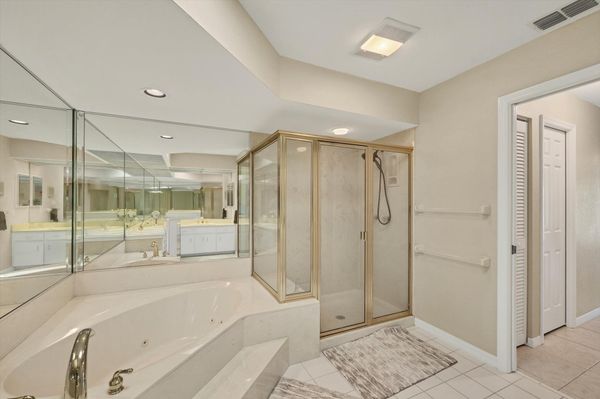 Primary Bathroom with large walk-in shower, double vanities, and bath tub