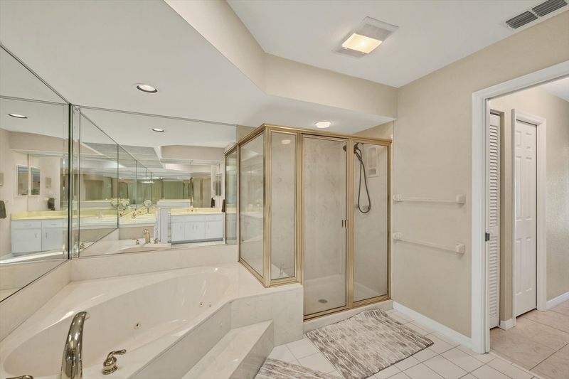 Primary Bathroom with large walk-in shower, double vanities, and bath tub
