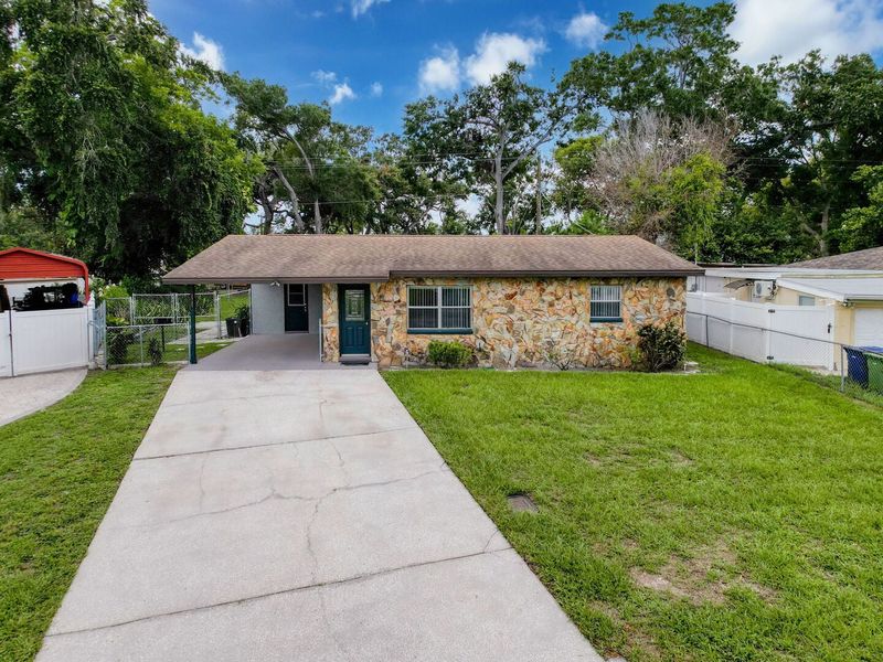 Exterior front with driveway and single car carport