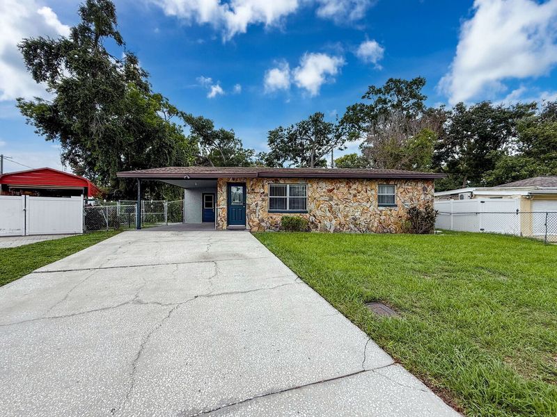Exterior front with driveway and single car carport