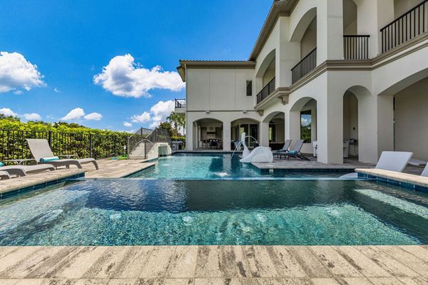Relax by the sparkling private pool featuring soothing fountains, in-pool loungers, and a built-in slide for kids.