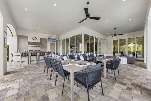 Dine al fresco in style with seating for up to 26 guests. This spacious covered patio features a full outdoor kitchen, bar seating, and plenty of dining tables. Enjoy the built-in TV or gather for movie nights on the 120" outdoor projector