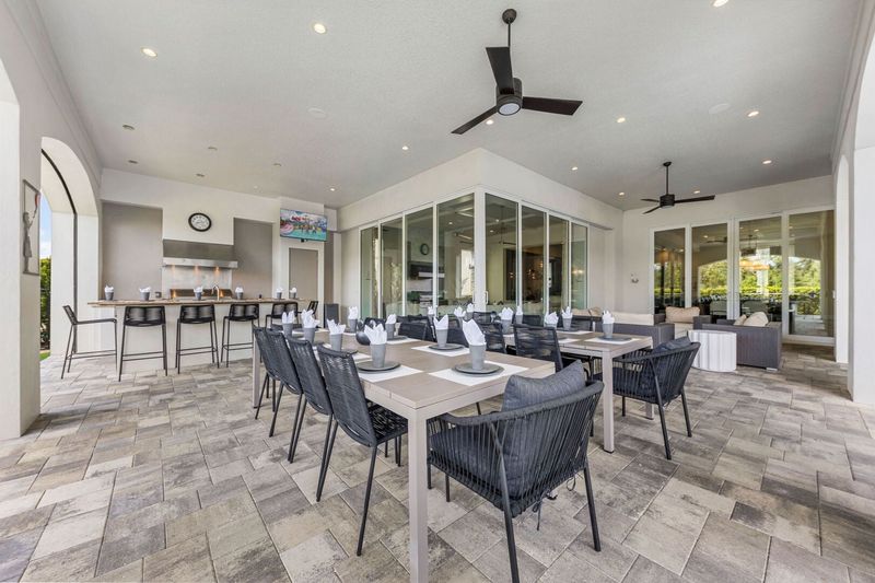 Dine al fresco in style with seating for up to 26 guests. This spacious covered patio features a full outdoor kitchen, bar seating, and plenty of dining tables. Enjoy the built-in TV or gather for movie nights on the 120" outdoor projector