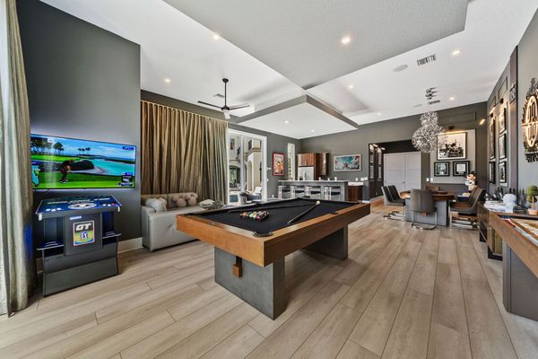 Elegant game room is the perfect retreat for grown-ups. Enjoy a round of billiards, relax in the stylish lounge seating, or sip cocktails at the sleek bar area.